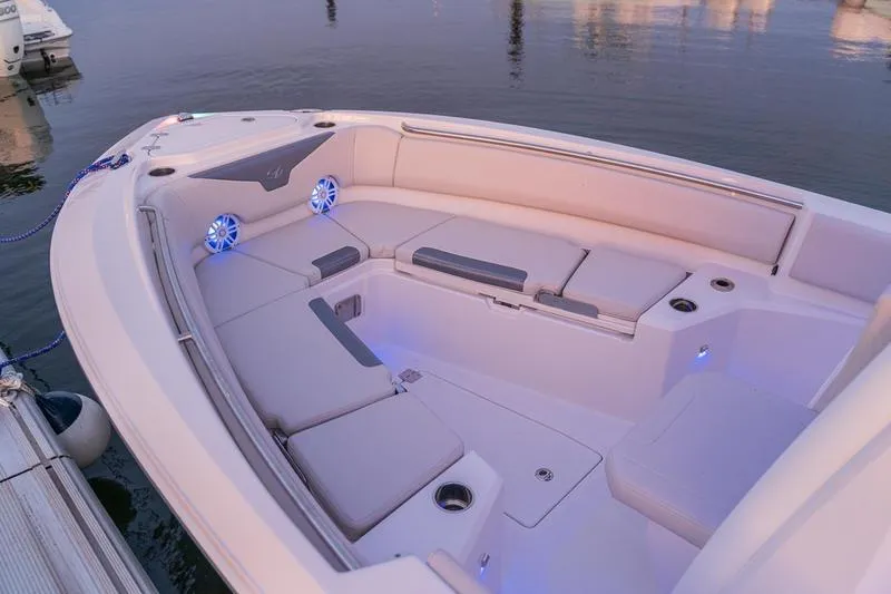 Slide: The Image of 2026 Sailfish 232 CC boat interior with cushioned seating and blue LED lights. - 13