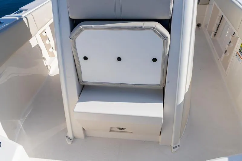 Slide: The Image of 2026 Sailfish 232 CC boat interior with cushioned seating and storage compartment. - 20