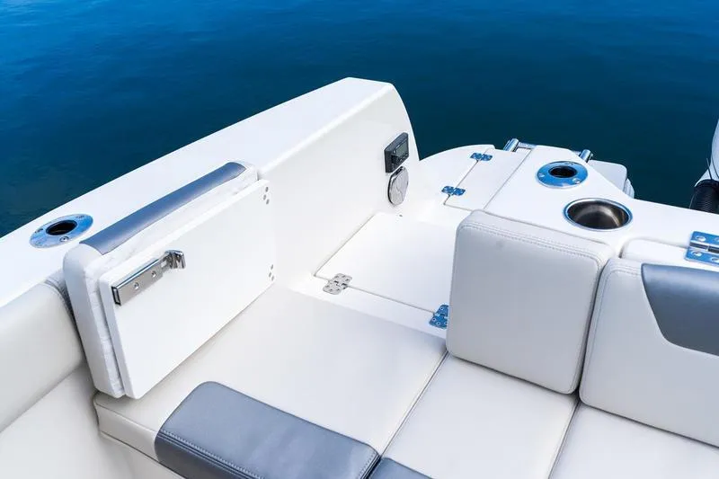Slide: The Image of 2026 Sailfish 232 CC boat interior with seating and cup holders on calm water. - 28