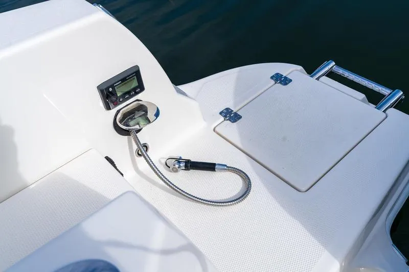 Slide: The Image of 2026 Sailfish 232 CC boat deck with control panel and hose attachment. - 31