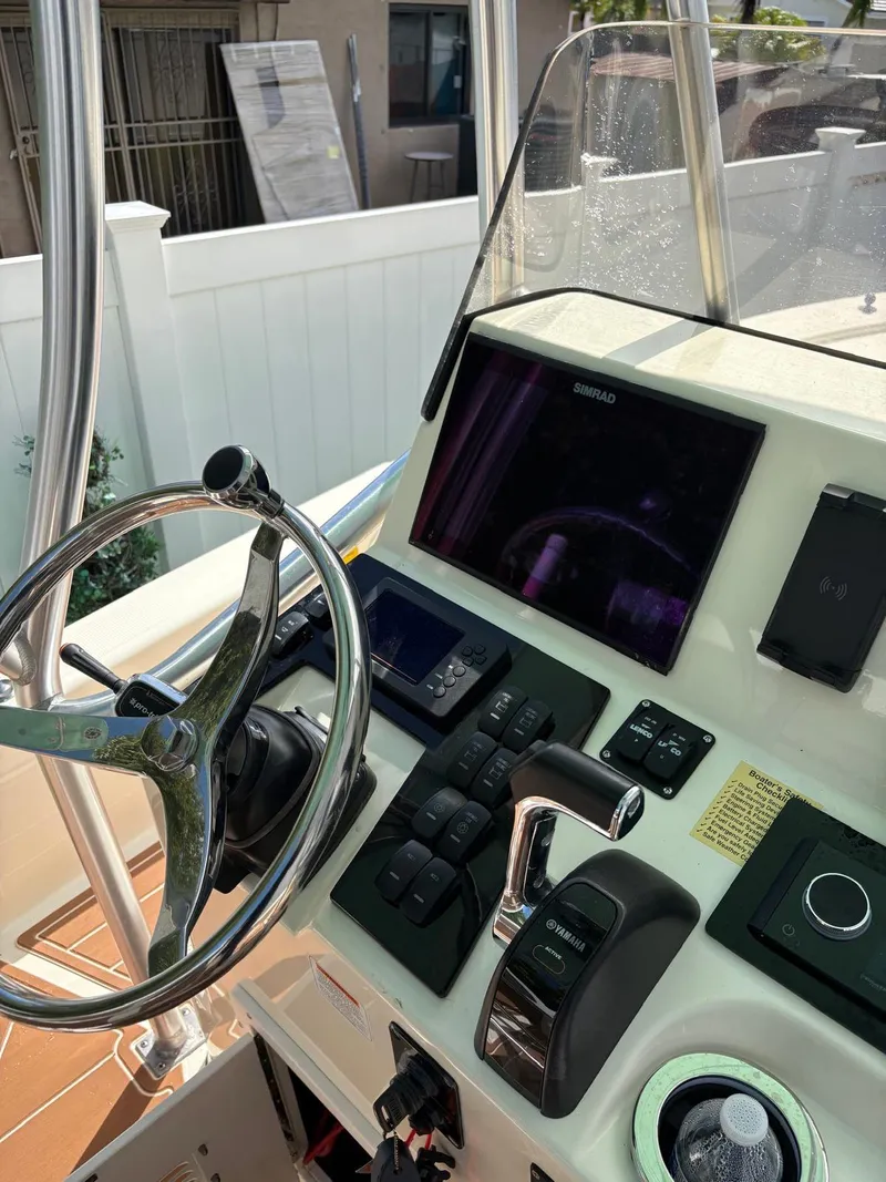 Slide: The Image of 2019 BlackJack 224 boat console with steering wheel, controls, and navigation display. - 17