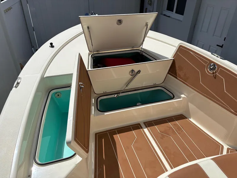 Slide: The Image of 2019 BlackJack 224 boat with open storage compartments and teak-style flooring. - 21