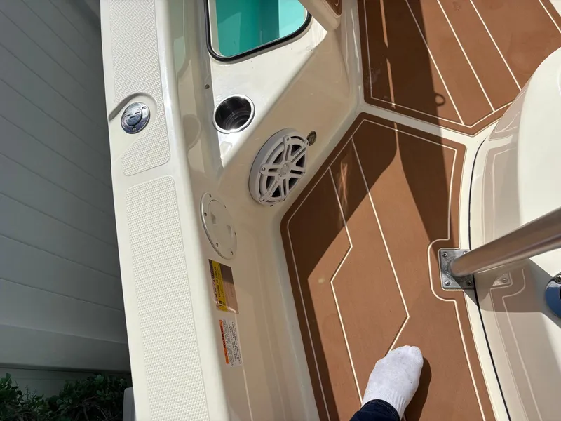 Slide: The Image of Interior of 2019 BlackJack 224 boat with brown flooring and speaker. - 23