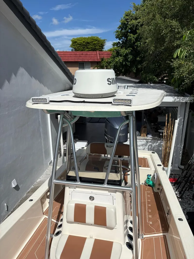 Slide: The Image of 2019 BlackJack 224 boat with radar, parked beside a house under clear blue sky. - 30