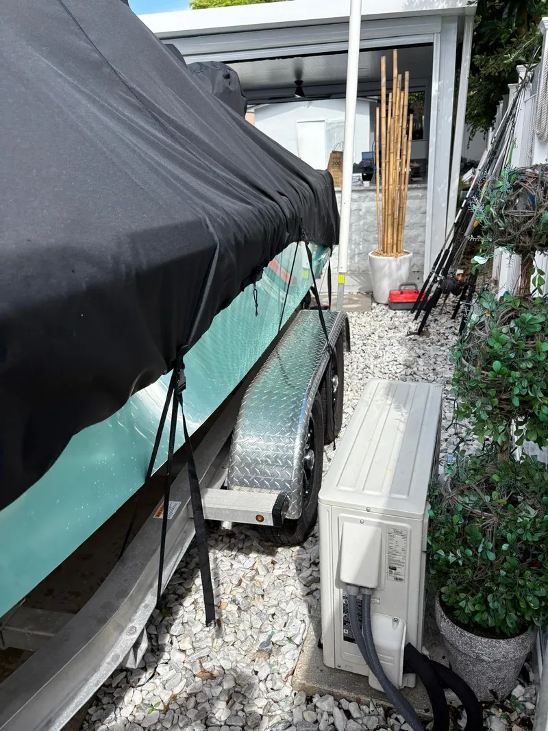 Slide: The Image of Covered BlackJack 224 boat on trailer beside air conditioning unit, 2019 model. - 38