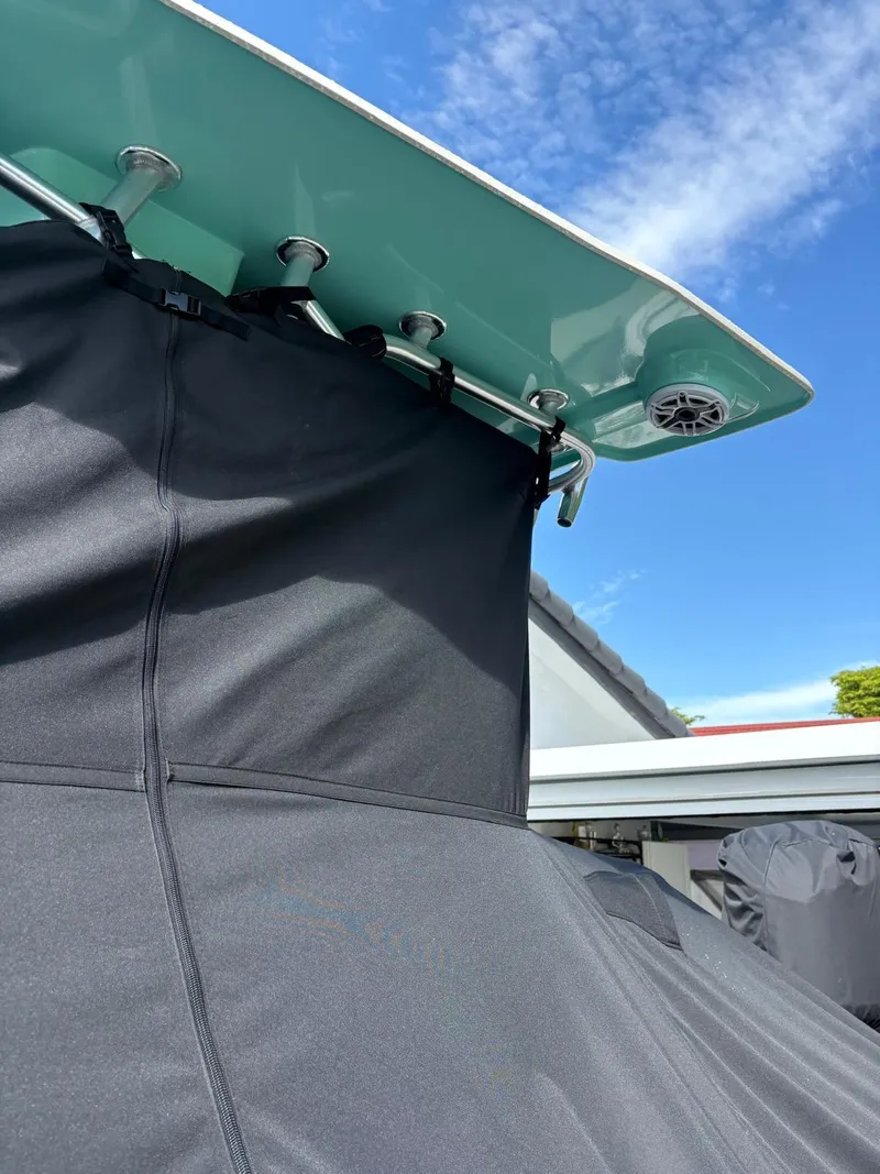 Slide: The Image of BlackJack 224 boat with black cover and teal top against blue sky, 2019 model. - 39