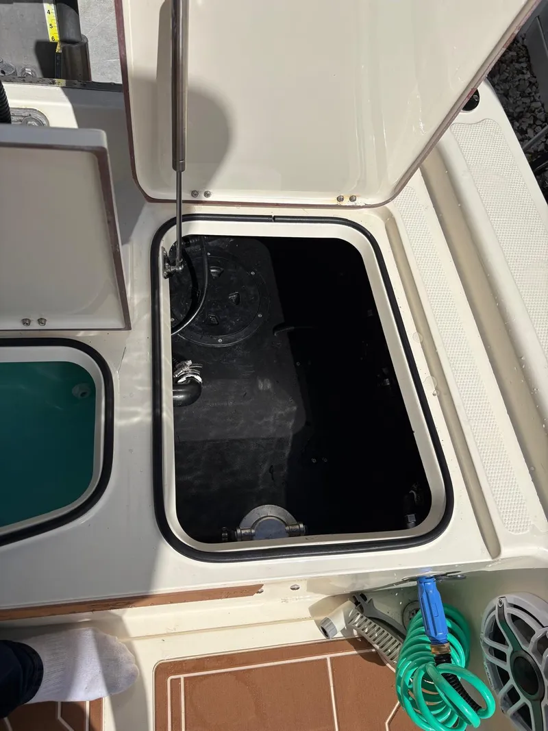Slide: The Image of Open hatch on 2019 BlackJack 224 boat, revealing storage compartment. - 6