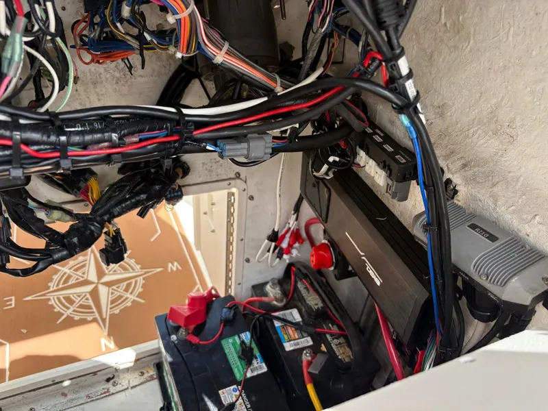 Slide: The Image of Electrical wiring and components inside a 2019 BlackJack 224 boat, featuring a battery and fuse box. - 9