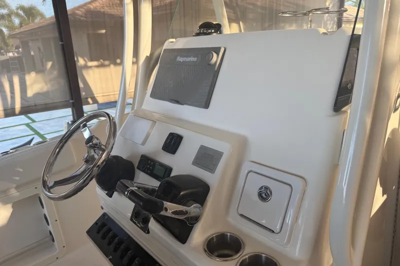 Slide: The Image of 2017 Century 2600 Center Console boat interior under canopy, featuring steering wheel and seating. - 14