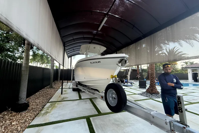 Slide: The Image of 2017 Century 2600 Center Console boat on trailer under canopy. - 24