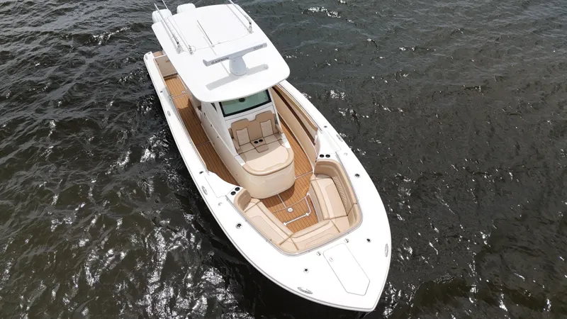 Slide: The Image of 2022 Scout 330 LXF boat on water, aerial view, showcasing sleek design and spacious deck. - 11
