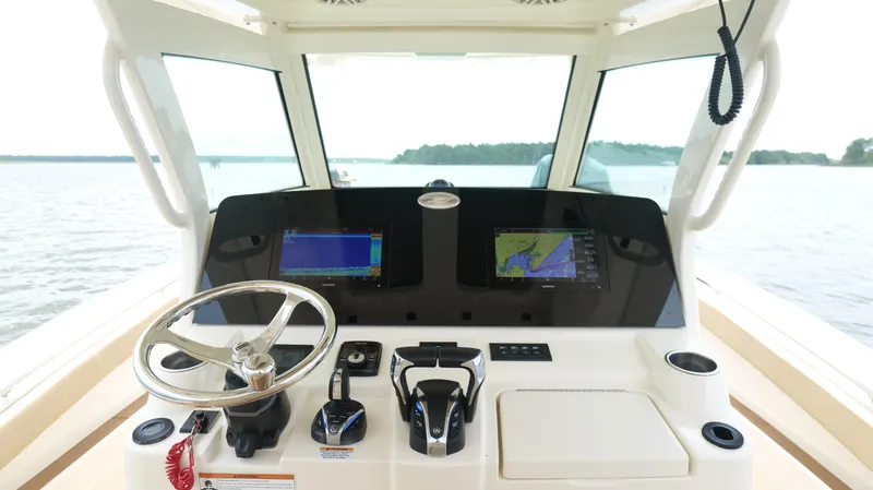 Slide: The Image of 2022 Scout 330 LXF boat dashboard with navigation screens and steering wheel. - 13