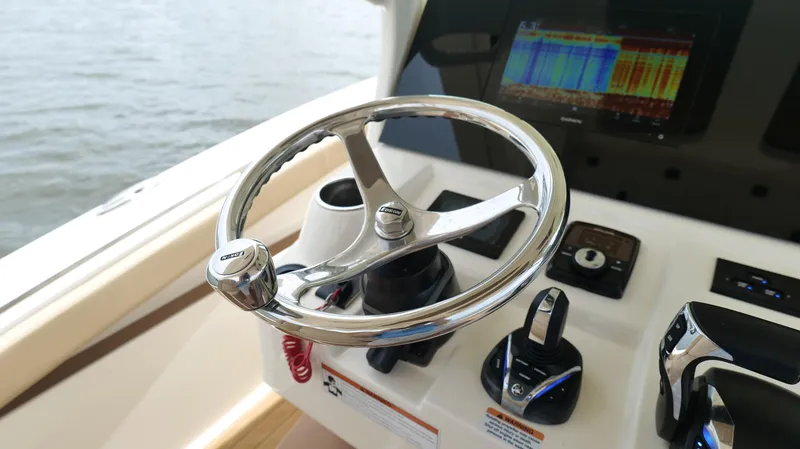 Slide: The Image of Steering wheel and controls of 2022 Scout 330 LXF boat, featuring advanced navigation display. - 15
