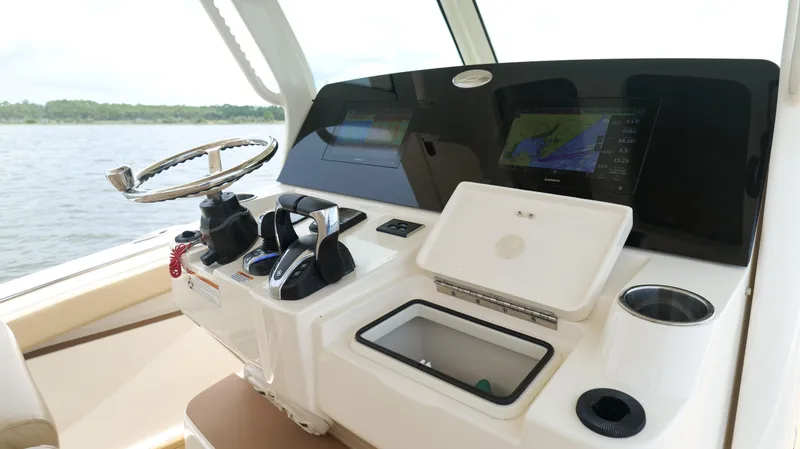 Slide: The Image of 2022 Scout 330 LXF boat dashboard with navigation screens and steering wheel. - 17