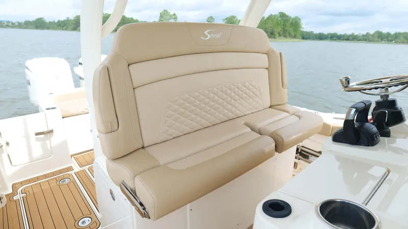 Slide: The Image of 2022 Scout 330 LXF boat interior with beige seating and steering wheel. - 21
