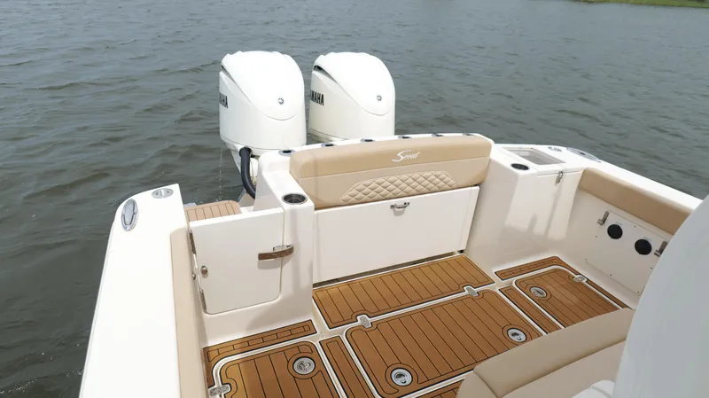 Slide: The Image of 2022 Scout 330 LXF boat with Yamaha engines, featuring teak flooring and cushioned seating. - 25