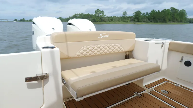 Slide: The Image of 2022 Scout 330 LXF boat with beige seating and dual engines on a lake. - 27
