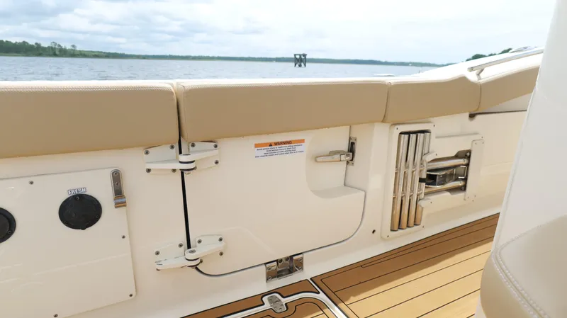 Slide: The Image of 2022 Scout 330 LXF boat interior with beige seating and teak flooring. - 32