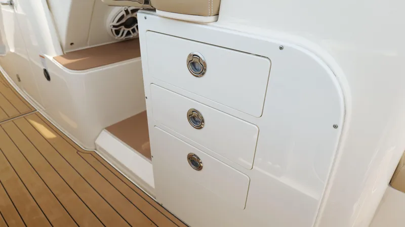 Slide: The Image of 2022 Scout 330 LXF boat interior with sleek storage drawers and teak flooring. - 34