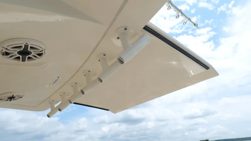 Slide: The Image of 2022 Scout 330 LXF boat with rod holders and speakers under a clear sky. - 36