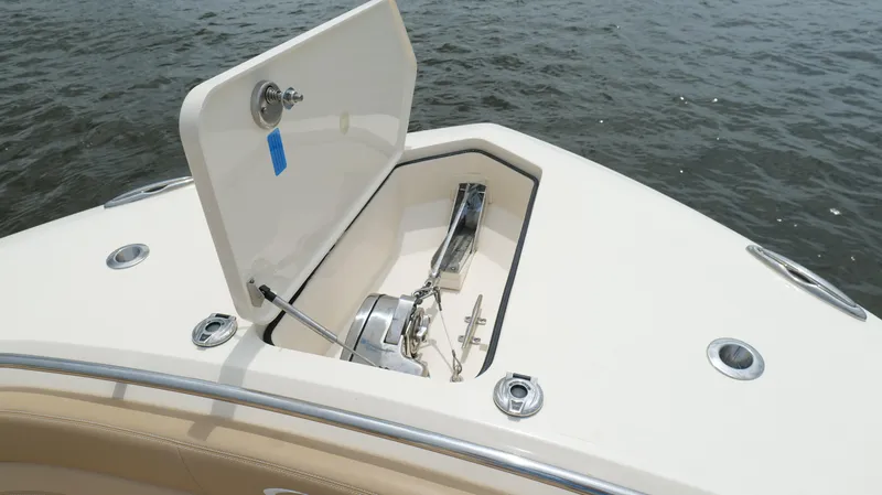 Slide: The Image of 2022 Scout 330 LXF boat anchor compartment open on calm water. - 43