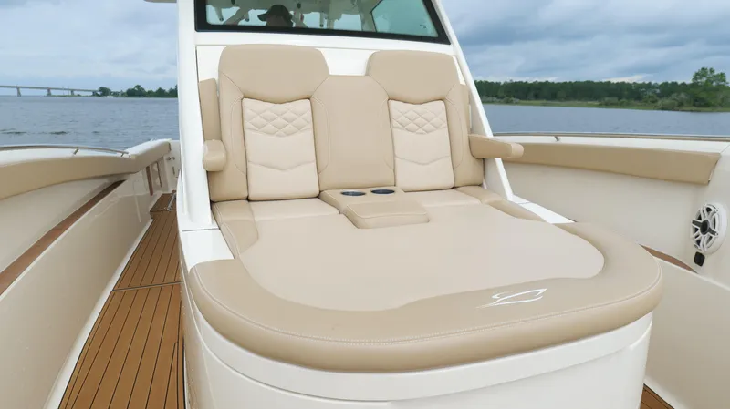 Slide: The Image of Luxurious seating on 2022 Scout 330 LXF boat, featuring beige upholstery and cup holders. - 45