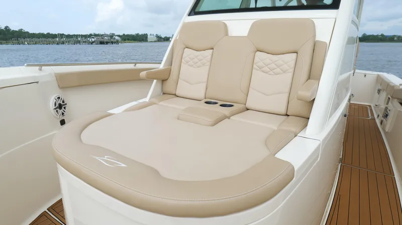 Slide: The Image of Luxurious seating on 2022 Scout 330 LXF boat with beige upholstery and cup holders. - 47