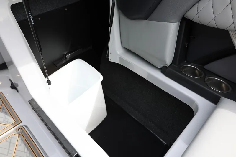 Slide: The Image of Interior storage compartment of 2025 Tigé Z3 boat with cup holders and white bin. - 29