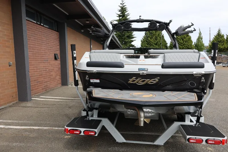 Slide: The Image of 2025 Tigé Z3 boat rear view, parked near a brick building. - 7