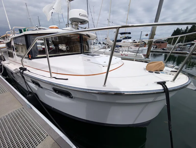 Slide: The Image of 2024 Ranger Tugs R27-OB boat docked at marina, featuring sleek design and modern equipment. - 2