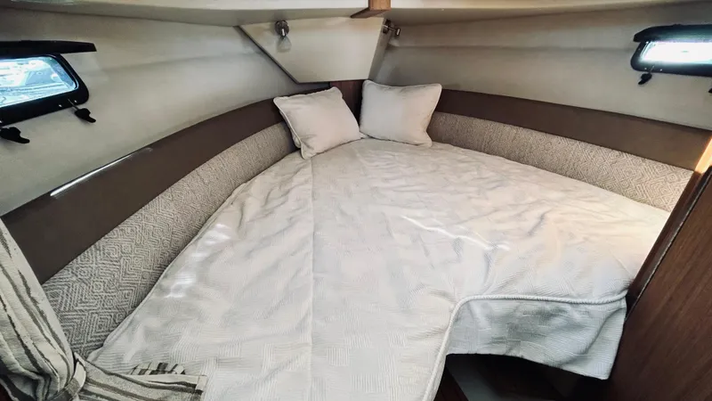 Slide: The Image of 2024 Ranger Tugs R27-OB cabin interior with cozy bed and pillows. - 23