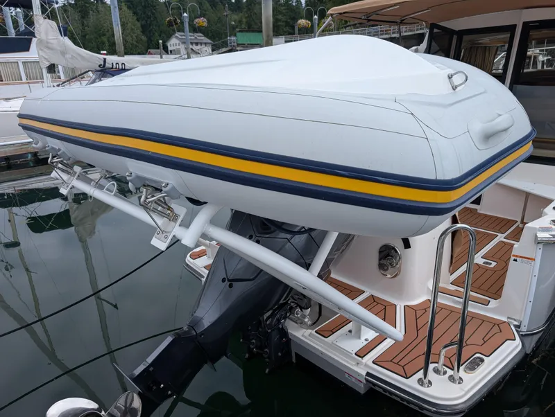 Slide: The Image of 2024 Ranger Tugs R27-OB with mounted inflatable boat at marina. - 29