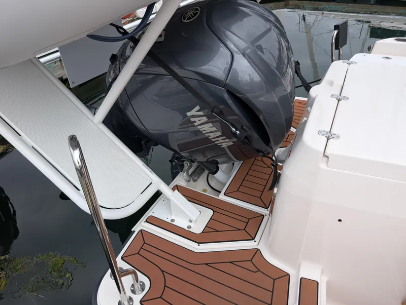 Slide: The Image of 2024 Ranger Tugs R27-OB with Yamaha outboard motor, featuring teak-style decking. - 32