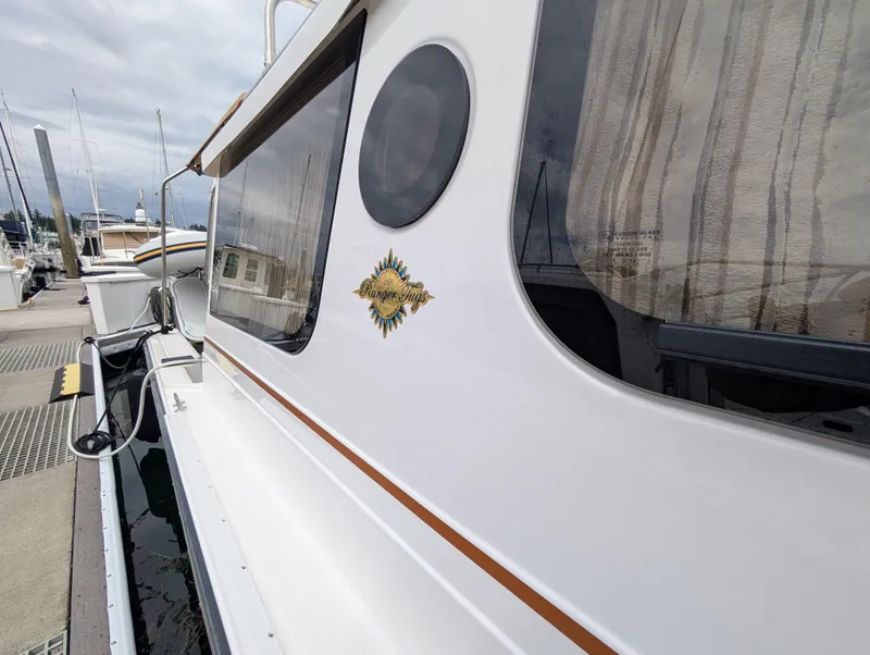 Slide: The Image of 2024 Ranger Tugs R27-OB boat docked, showcasing sleek design and logo. - 4