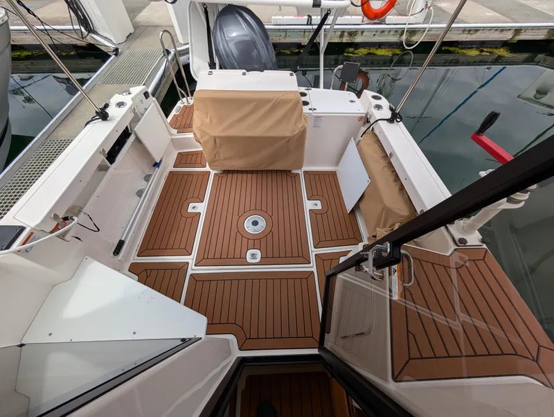 Slide: The Image of 2024 Ranger Tugs R27-OB boat deck with teak flooring and covered seating. - 7