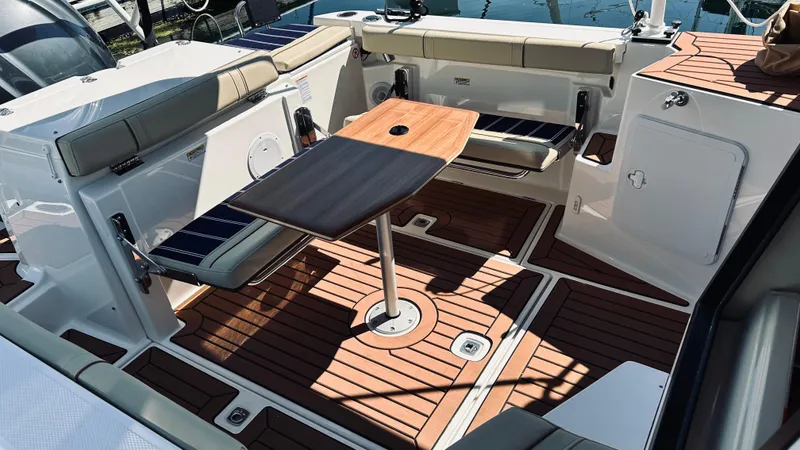 Slide: The Image of 2024 Ranger Tugs R27-OB boat interior with wood flooring and seating area. - 8