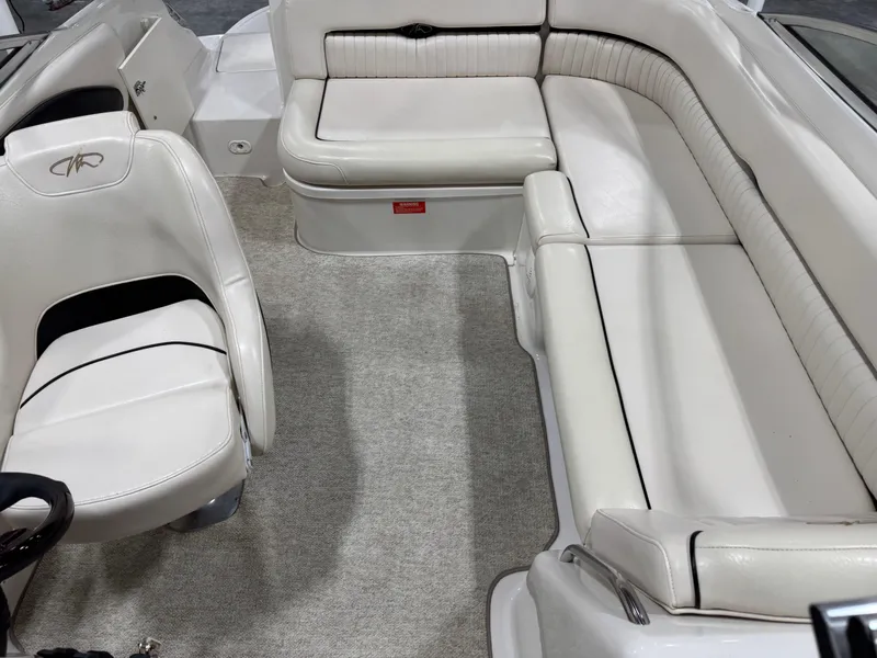 Slide: The Image of Interior of a 2002 Monterey 240 Explorer Sport boat with white seating and carpet. - 10