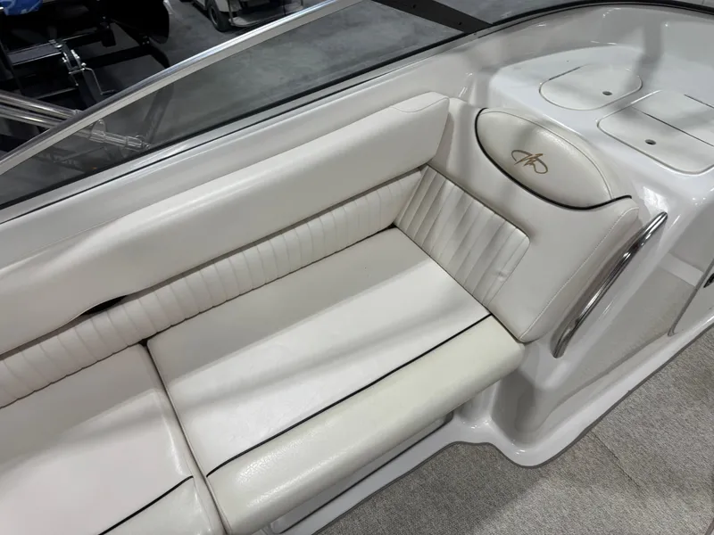 Slide: The Image of 2002 Monterey 240 Explorer Sport boat interior with white cushioned seating. - 11