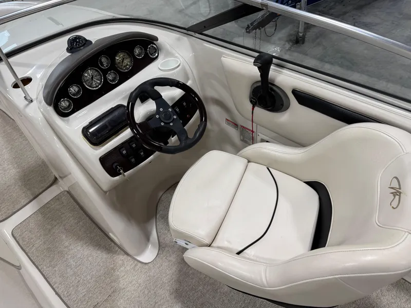 Slide: The Image of 2002 Monterey 240 Explorer Sport boat cockpit with steering wheel and gauges. - 12