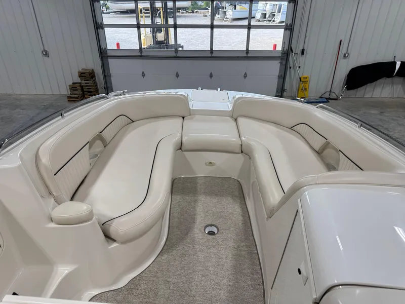 Slide: The Image of 2002 Monterey 240 Explorer Sport boat interior with beige seating and carpeted floor. - 13