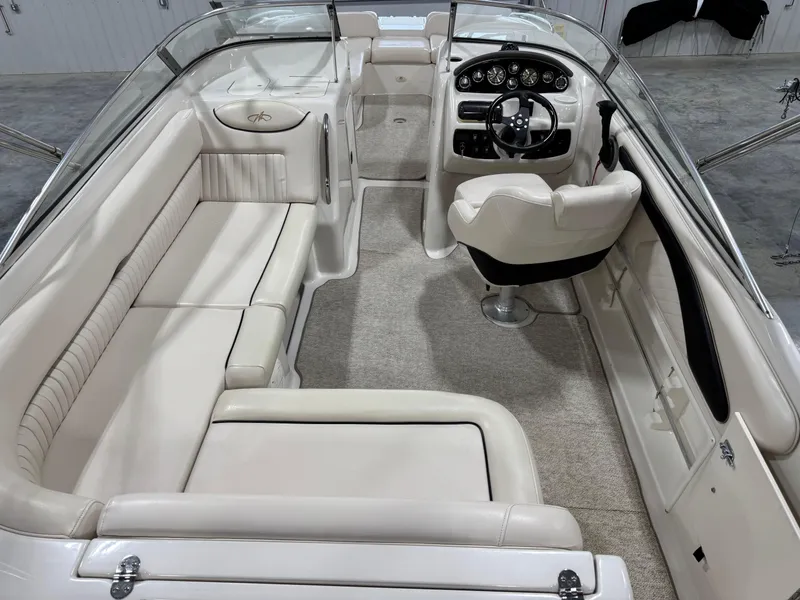 Slide: The Image of 2002 Monterey 240 Explorer Sport boat interior with white seating and modern dashboard. - 6
