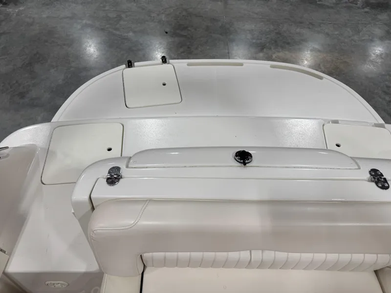 Slide: The Image of 2002 Monterey 240 Explorer Sport boat interior with white seating and storage compartments. - 7