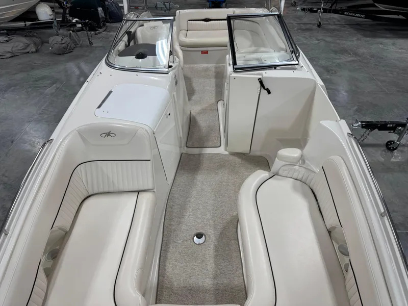 Slide: The Image of 2002 Monterey 240 Explorer Sport boat interior with white seating and carpeted floor. - 8