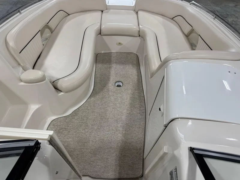 Slide: The Image of 2002 Monterey 240 Explorer Sport boat interior with beige seating and carpeted floor. - 9