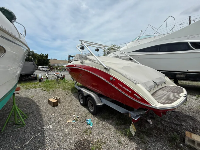 Slide: The Image of 2014 Yamaha Boats 242 Limited S, red, covered, on trailer, parked outdoors. - 4