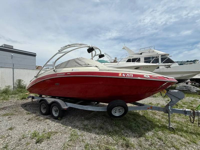 Slide: The Image of 2014 Yamaha Boats 242 Limited S, red, on trailer, parked outdoors. - 6