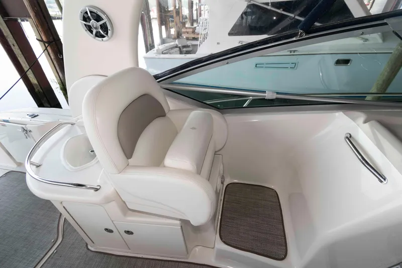 Slide: The Image of 2004 Sea Ray 340 Sundancer cockpit with steering wheel, gauges, and plush seating at marina. - 10