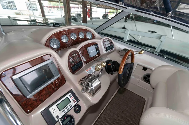 Slide: The Image of 2004 Sea Ray 340 Sundancer interior with seating, table, and sink in a covered dock. - 7