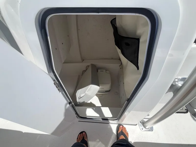 Slide: The Image of 2023 Sea Fox 248 Commander boat storage compartment with portable toilet and storage net. - 16