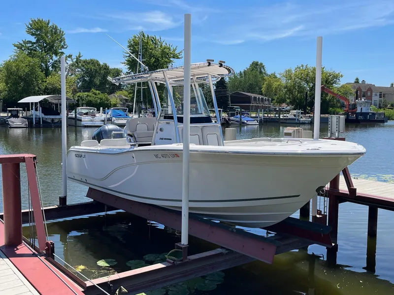 Slide: The Image of 2023 Sea Fox 248 Commander boat on lift at marina, sunny day. - 2